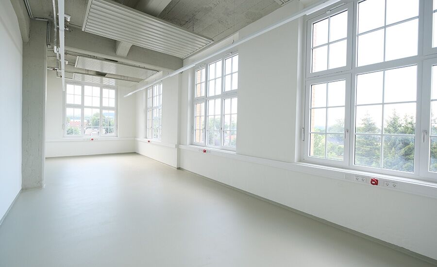 Leeres Atelier mit großen Fenstern und viel Raum