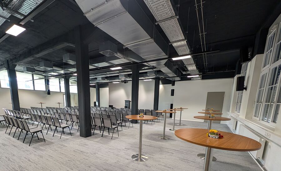 Konferenzraum mit Reihenbestuhlung und Stehtischen an der Seite